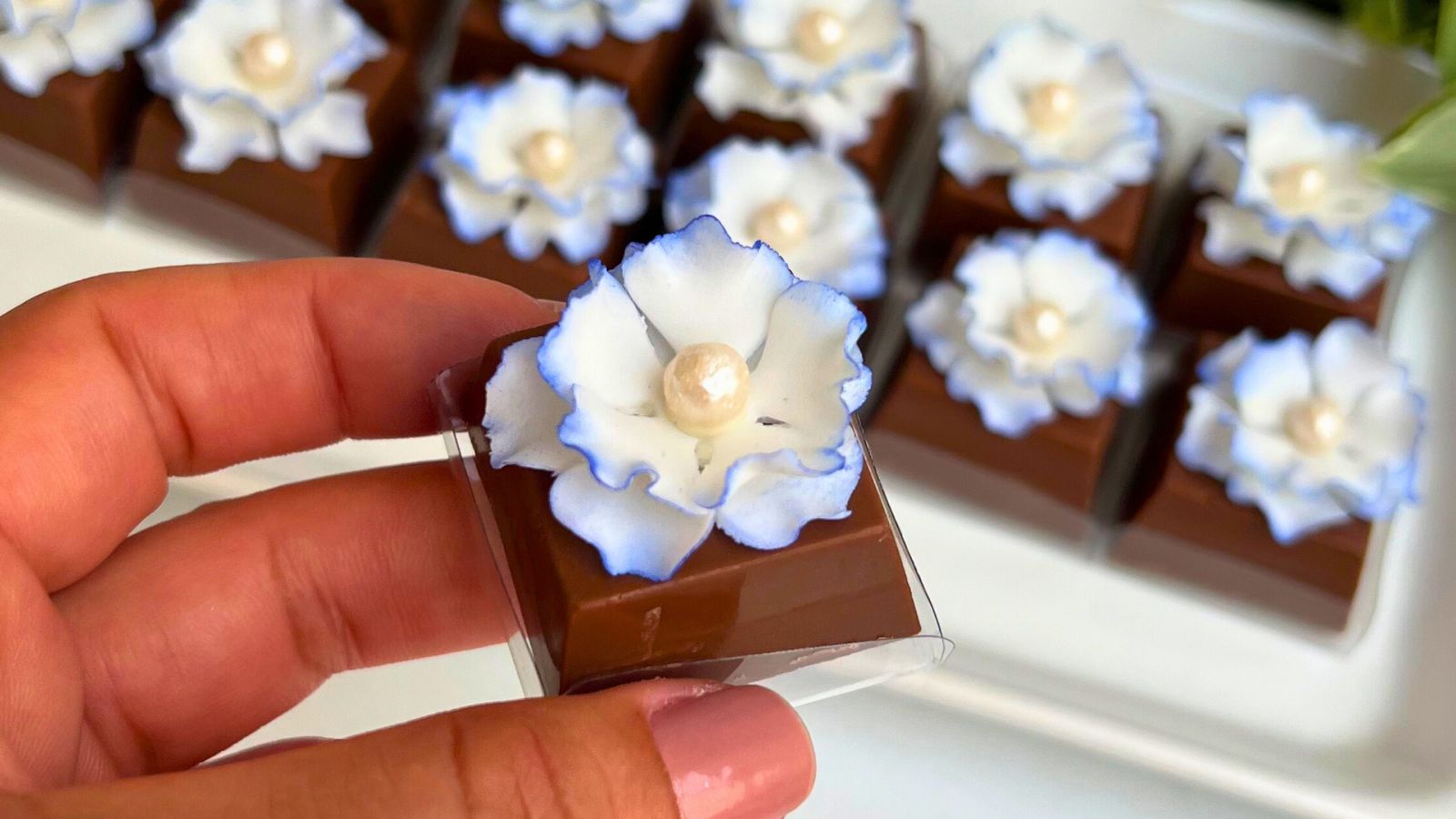Brigadeiro finalizado com mini flor branca de açúcar e pérola