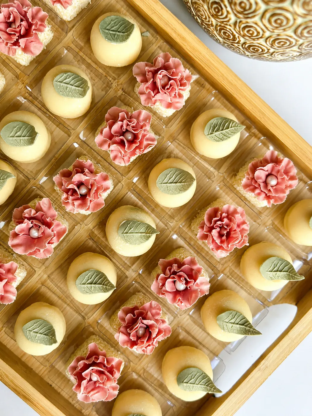 Doces finalizados com mini rosas do deserto de açúcar em bandeja de madeira
