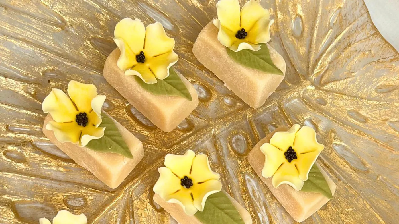 Doces finalizados com mini flores amarelas de açúcar